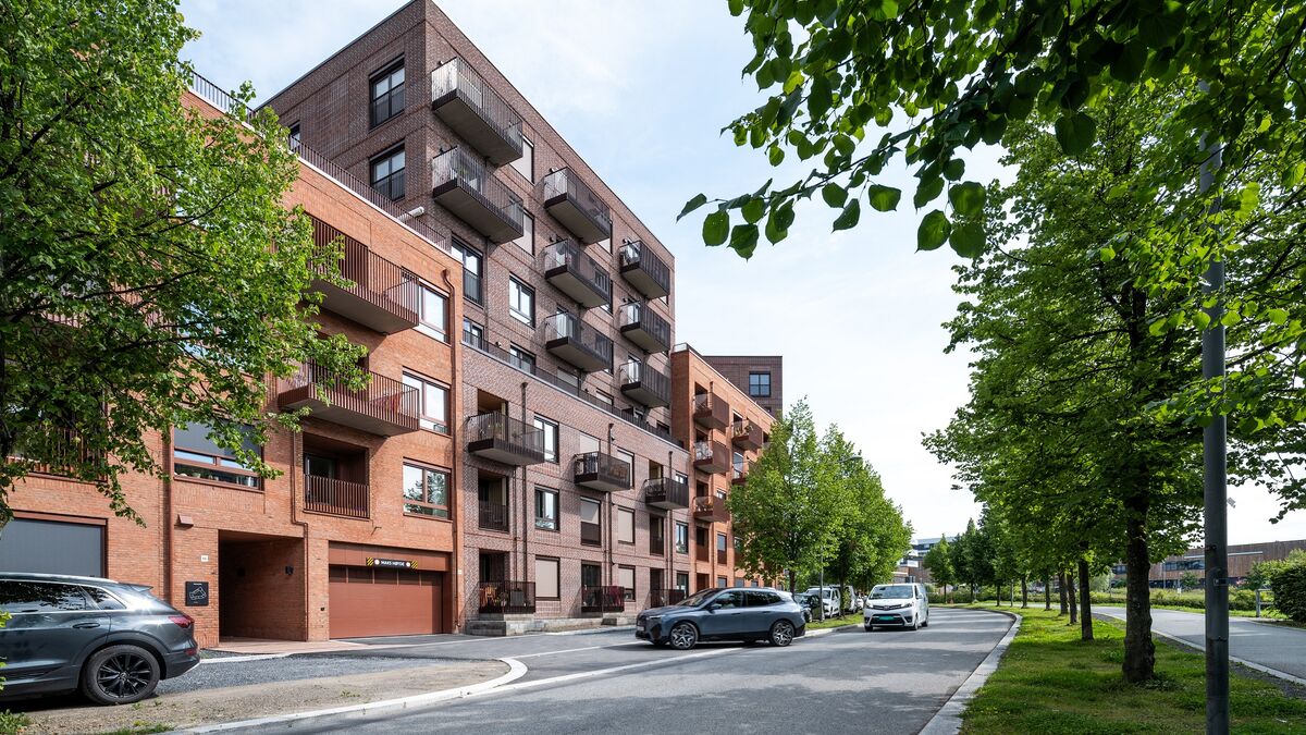 Modernt bostadsområde där ett fordon kör in i ett garage utrustat med ett integrerat parkeringssystem.
