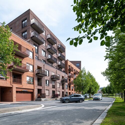 Modernt bostadsområde där ett fordon kör in i ett garage utrustat med ett integrerat parkeringssystem.