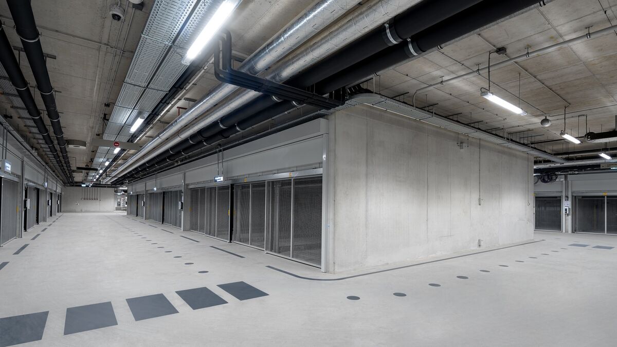 Modernt underjordiskt garage med korsningsområde, genomgående körbanor och parkeringssystem på båda sidor.
