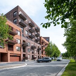 Modernt bostadsområde där ett fordon kör in i ett garage utrustat med ett integrerat parkeringssystem.