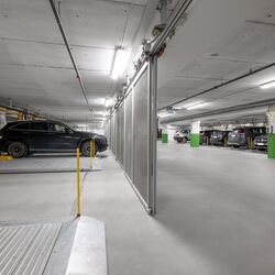 WÖHR parkeringsplattform 601 i ett underjordiskt garage med flera fordon på flyttbara parkeringsplattformar för optimal användning av det tillgängliga parkeringsutrymmet.